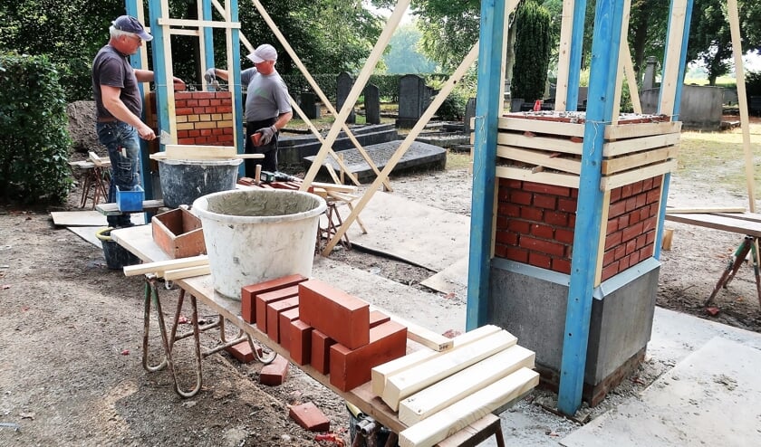 <p>Medewerkers van Bouwbedrijf Hoffman aan het werk met de nieuwe toegangspoort. Foto: Theo Huijskes</p>