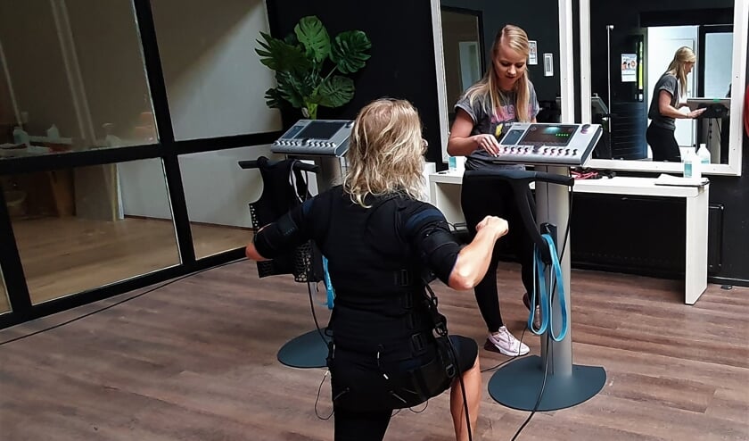 <p>Tijdens de Bodytec oefeningen voert trainer Annemarie Oudenampsen in overleg met de sporter langzaam de intensiteit van de elektrische impulsen op tot de gewenste sterkte. Foto: Bodytec Vorden</p>