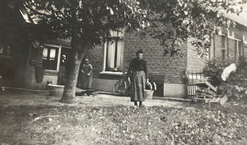<p>Boerderij de Ruiterskamp, met op de voorgrond Opoe Gerritje Izaks-Hasselo en op de achtergrond: Hanna Izaks, een zus van opa; daarachter in de deuropening opa’s moeder, Egberdina Grooters. Foto: privé-archief Derk Willem Izaks </p>