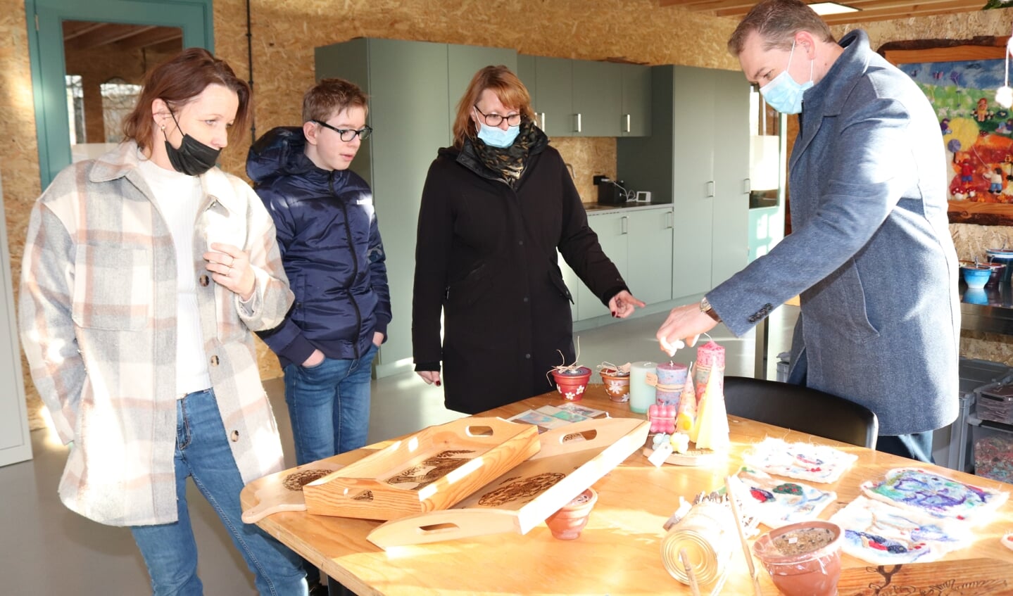 Begeleidster Daniëlle Woestenenk (l) en Finn (midden) laten Finns ouders de uitgestalde werkstukken zien. Foto: Arjen Dieperink