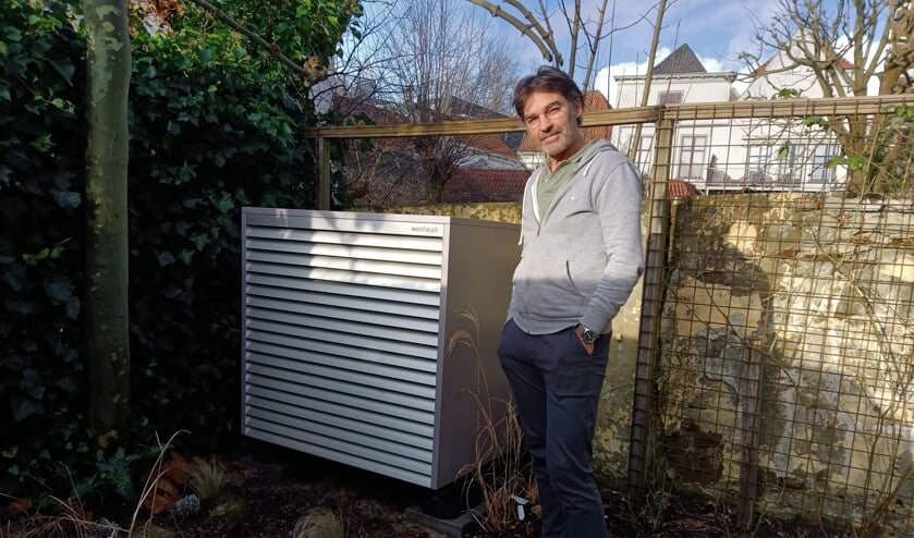 Stijn van Wely bij de warmtepomp in de tuin van zijn negentiende-eeuwse woning aan de Boompjeswal. Foto: Rudi Hofman