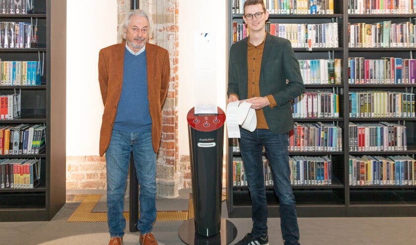 August Hans den Boef, voorzitter Stichting Zutphen Literair en wethouder Mathijs ten Broeke bij de verhalenautomaat in de Zutphense bibliotheek. Foto: Henk Derksen
