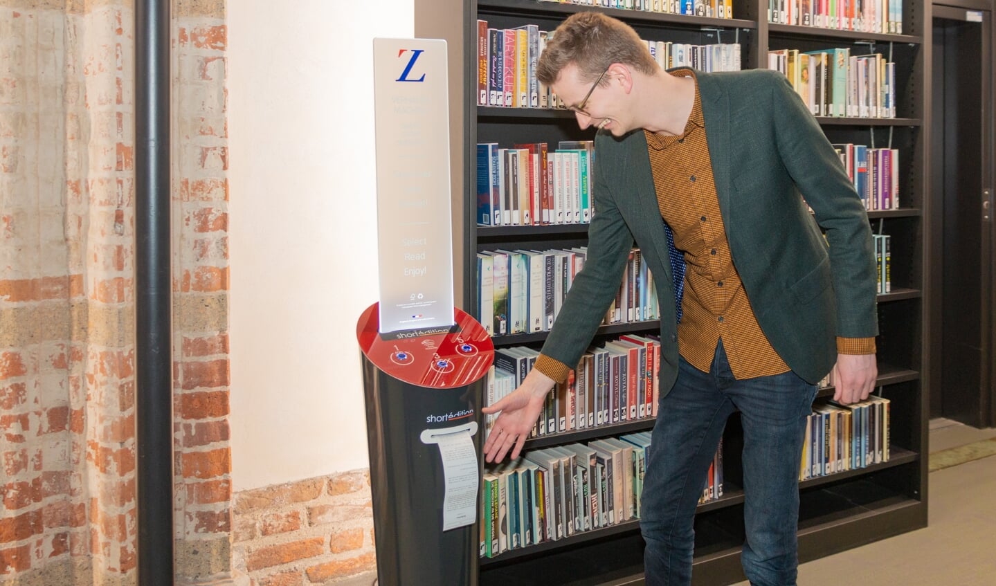Wethouder Ten Broeke neemt het eerste verhaal uit de verhalenautomaat in ontvangst in de Zutphense bibliotheek. Foto: Henk Derksen