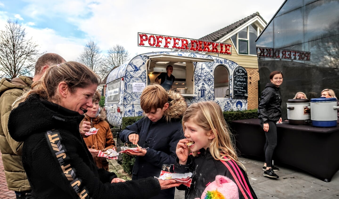 Een gezin geniet van de poffertjes. Foto: Luuk Stam