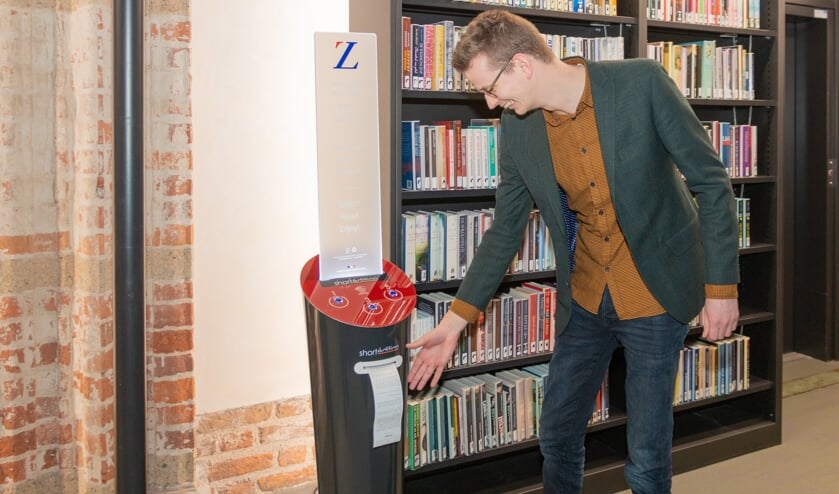 Wethouder Ten Broeke neemt het eerste verhaal uit de verhalenautomaat in ontvangst in de Zutphense bibliotheek. Foto: Henk Derksen