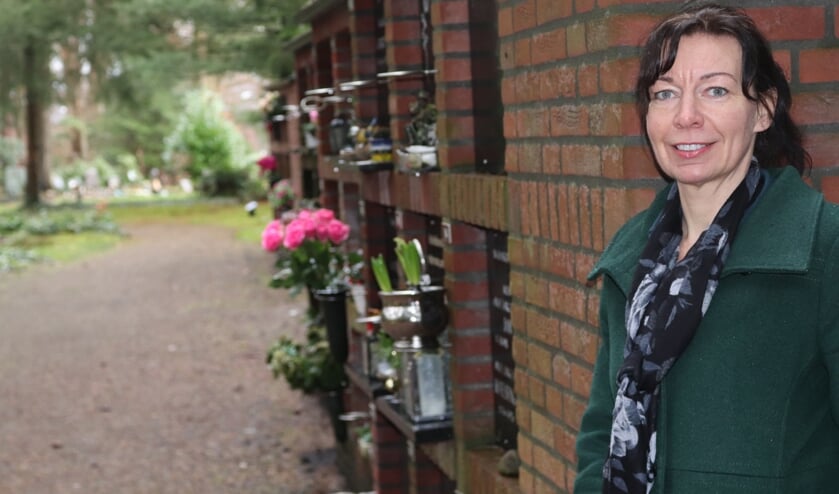 <p>Ester Dolphijn bij de urnenmuur op de begraafplaats Lochem. "Het is de laatste tijd wel drukker in onze branche." Foto: Arjen Dieperink</p>