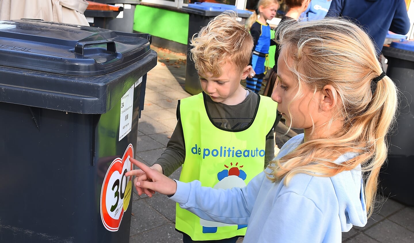 Kinderen plakken 30 km stickers op kliko's in Breedenbroek. Foto: Roel Kleinpenning