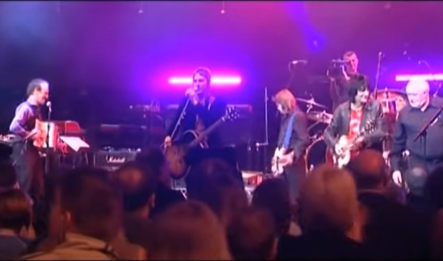 Charlie Hart (links) deelt tijdens het Ronnie Lane Memorial Concert in 2004 het podium met Paul Weller (midden) en Ronnie Wood (tweede van rechts). Bron: still uit YouTube-video,