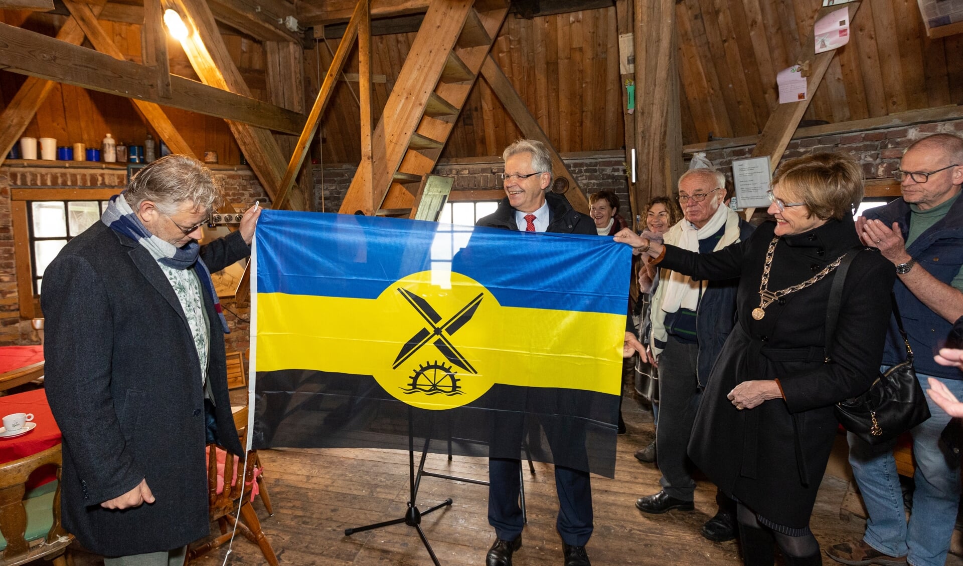 Peter Drenth, Jos Penninx en burgemeester Bronsvoort tonen de nieuwe Gelderse molenvlag. Foto: Fotostudio Jurgen Pillen 