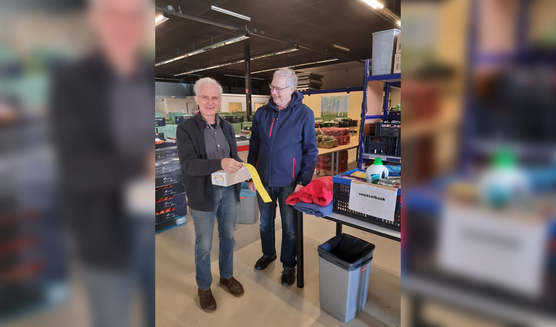 Jan van Bolderen, diaken van de Protestantse Gemeente Vorden (r) overhandigt Johan Huiskamp van de Voedselbank Zutphen diverse artikelen en een bedrag van 2363 euro. Foto: PR