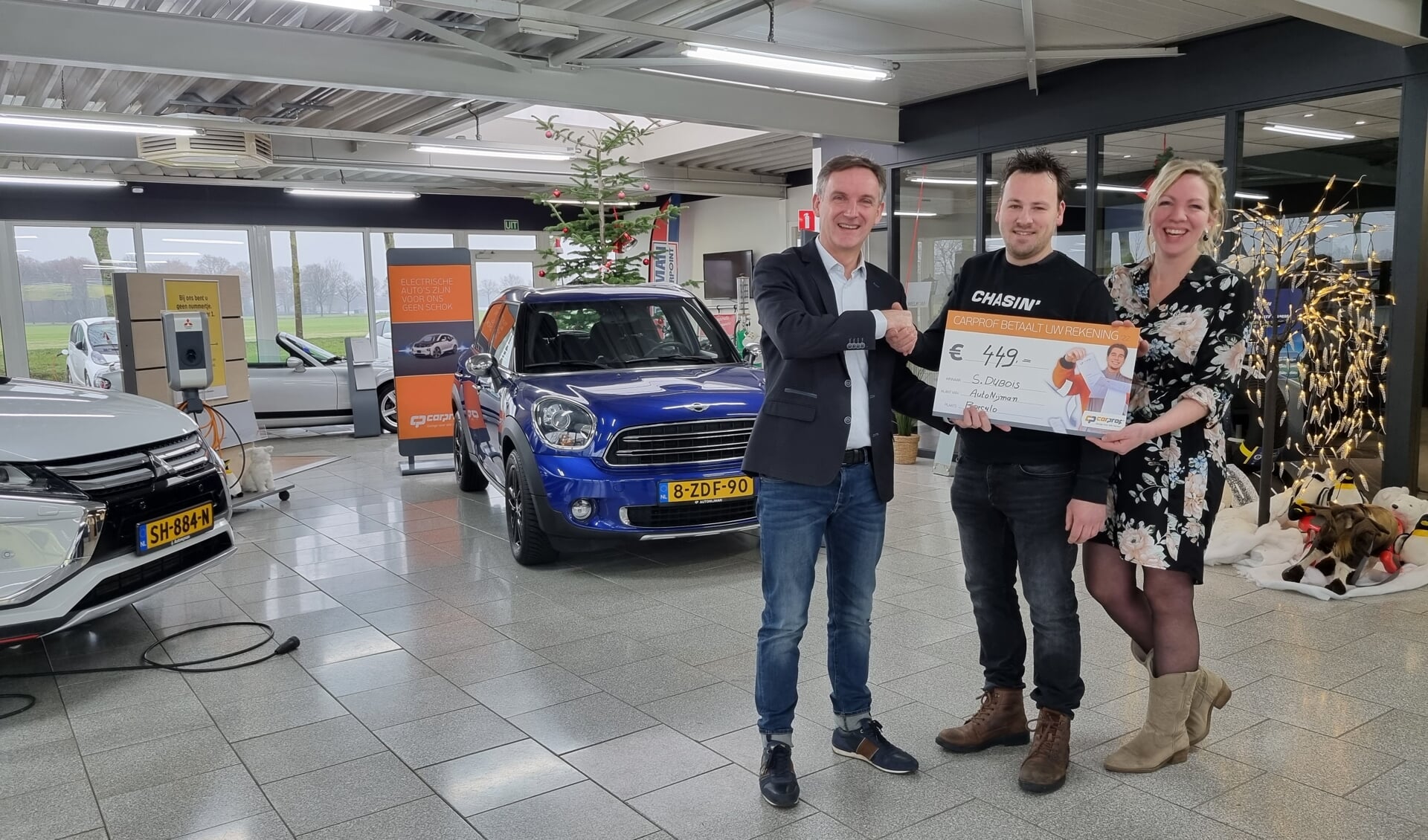 Adri Nijman reikt de cheque uit aan de winnaar van de ‘CarProf Betaalt Uw Rekening’ actie. Foto: PR
