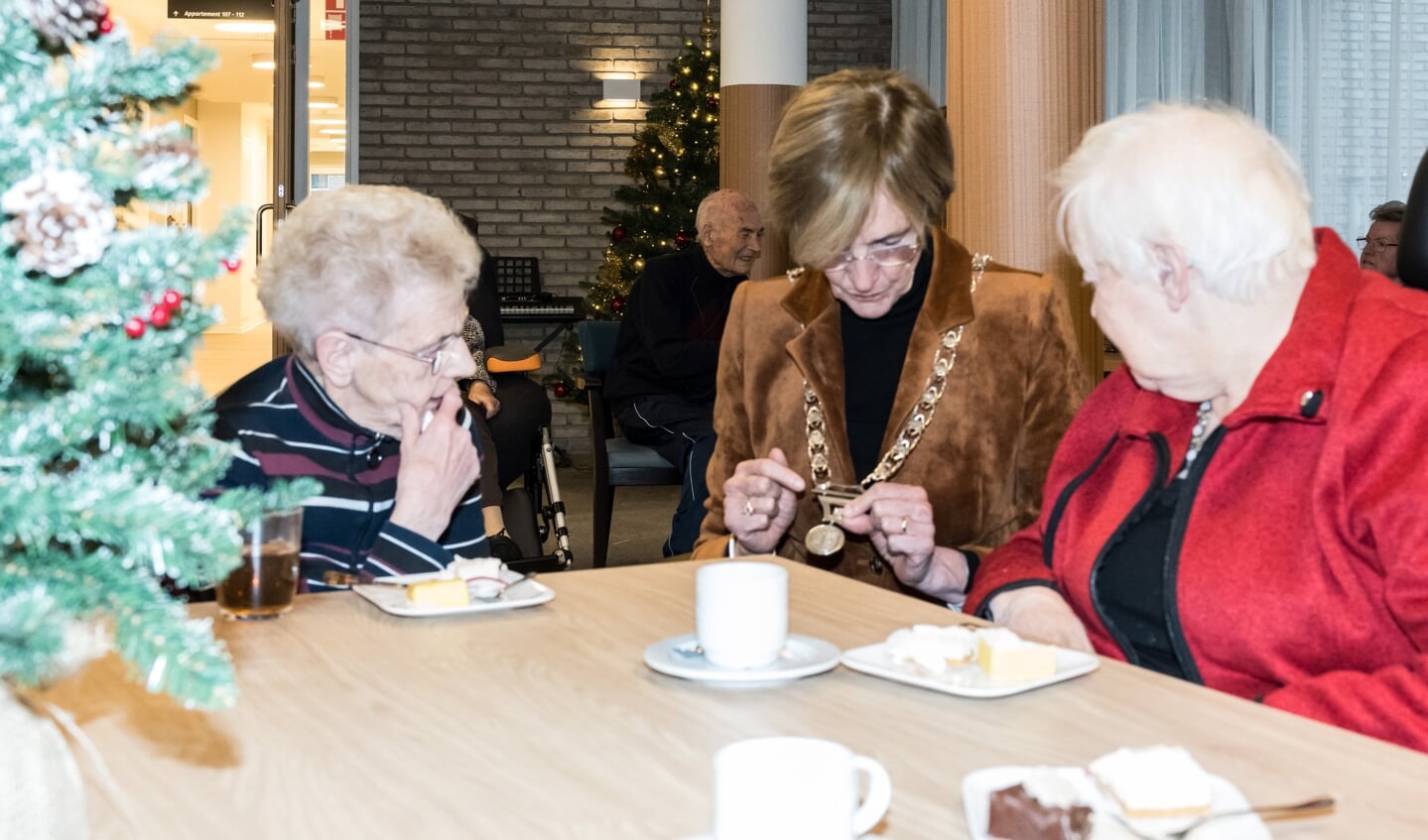 Burgemeester Bronsvoort legt uit waar de tekens op haar ambtsketting voor staan aan de  dames Molleman en Hulshof. Foto: Janette van Egten