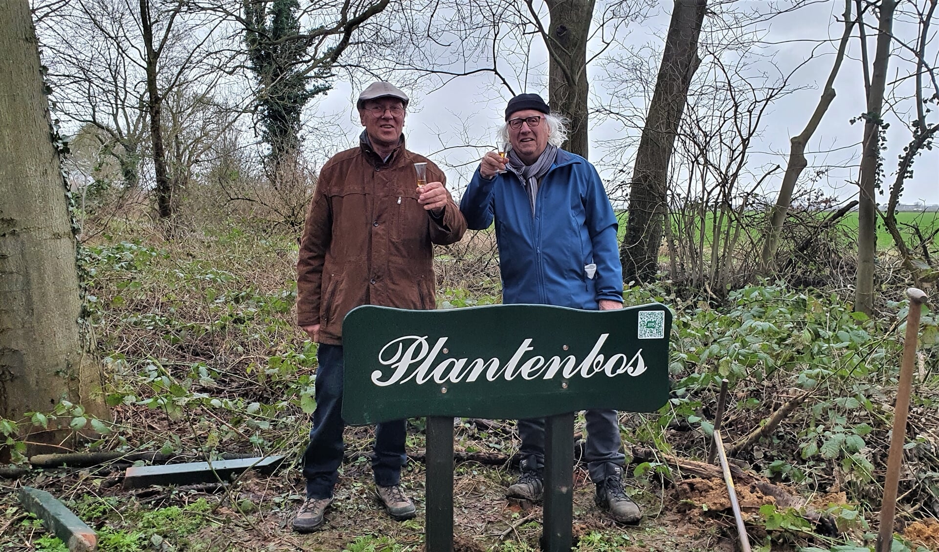 De heren Rob Planten en Geert Jansen heffen het glas op het herplaatsen van het naambord Plantenbos. Foto: Alice Rouwhorst