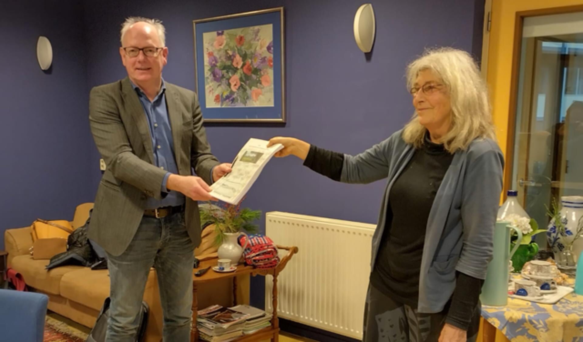 Initiatiefnemer Marlies Gommers overhandigt de petitie 'Steun de bewoners van de Bloemenkamp' aan Peter Boerenfijn, directeur/bestuurder van Habion/VGZ. Foto: PR