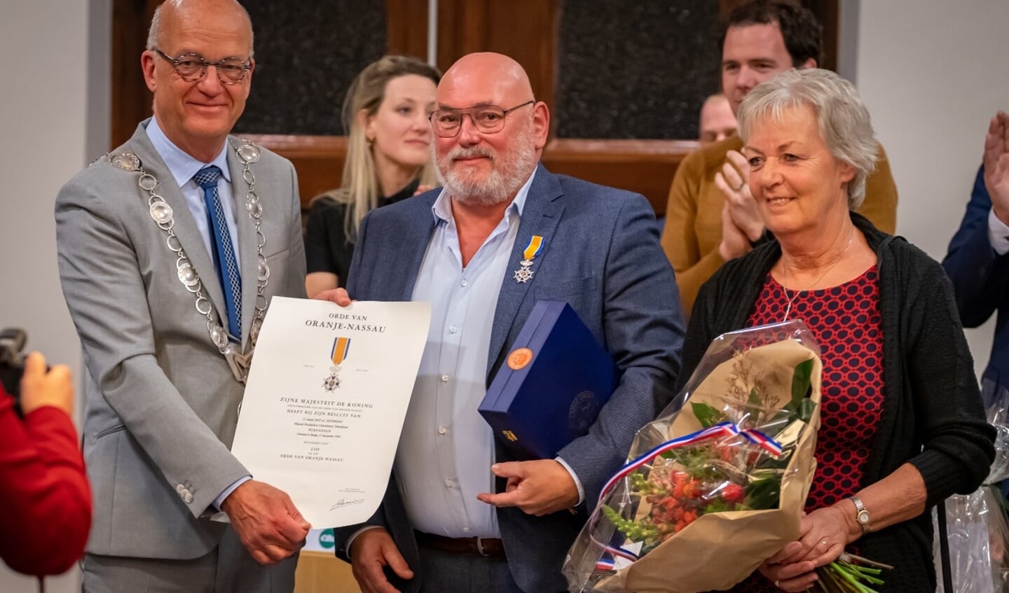 Burgemeester Harry de Vries rijkt de versierselen en oorkonde uit aan Marcel Berendsen.