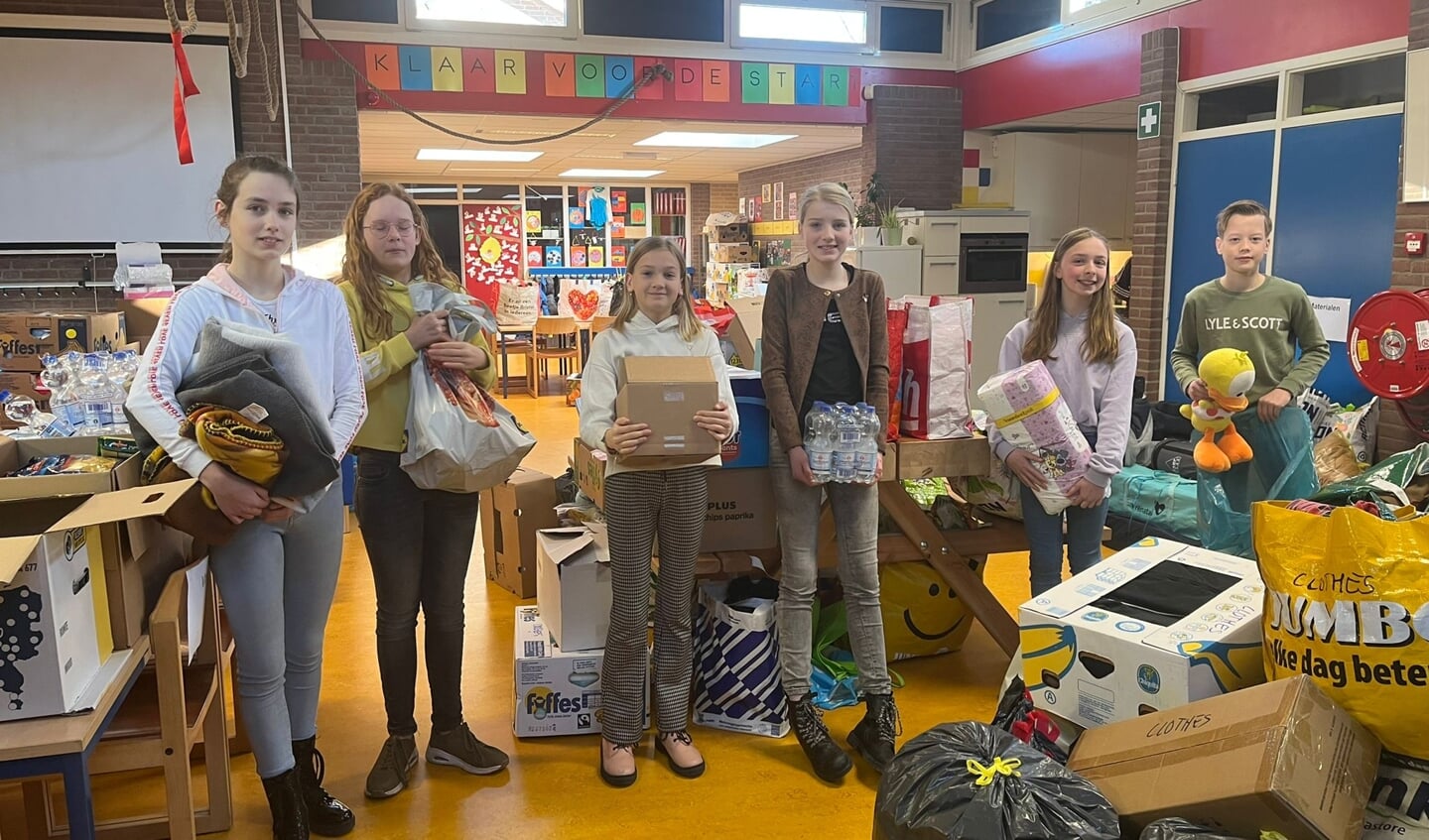 Leerlingen bij de ingezamelde spullen voor Oekraïne op basisschool Menno ter Braak. Foto: PR