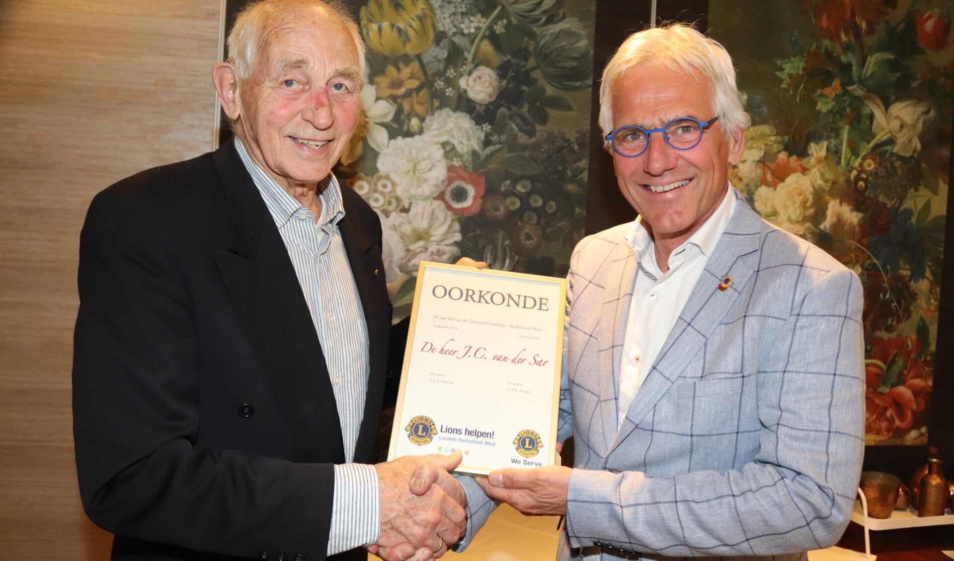Jan van de Sar (l) ontvangt van districtsgouverneur Wierdy de Haan (r) de oorkonde voor het 50-jarig lidmaatschap. Foto: Arjen Dieperink