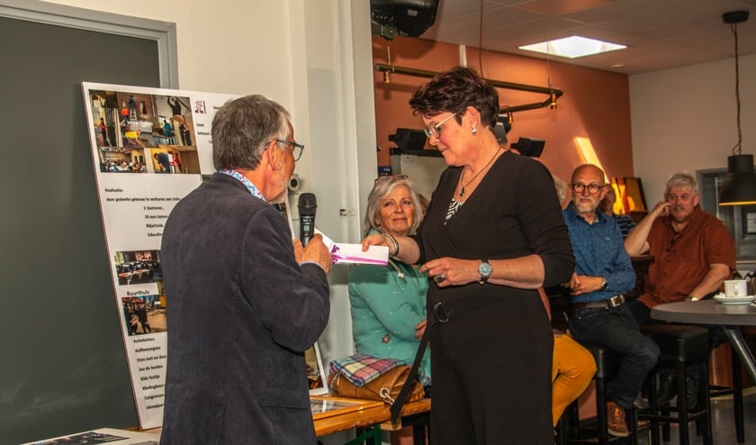 Wethouder Evert Blaauw  overhandigd Sandra Otten een enveloppe namens de gemeente Bronckhorst. Foto: Liesbeth Spaansen