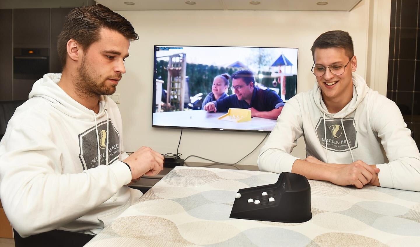 Daan (links) en Zowie met een onderdeel van het knikkerspel. Op de achtergrond een beeld uit hun promotiefilmpje. Foto: Roel Kleinpenning