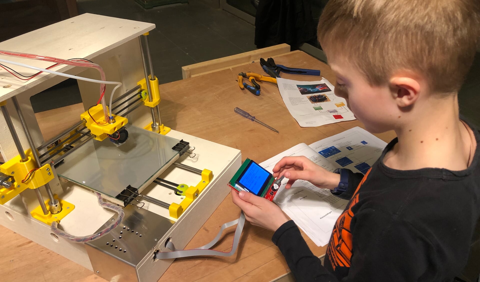 Een leerling aan het werk met een zelfgebouwde 3D-printer. Foto: PR