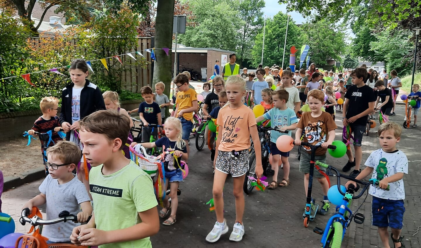 De oudere kinderen begeleiden de jongste bij een feestelijke rondje om de gracht. Foto: Kyra Broshuis