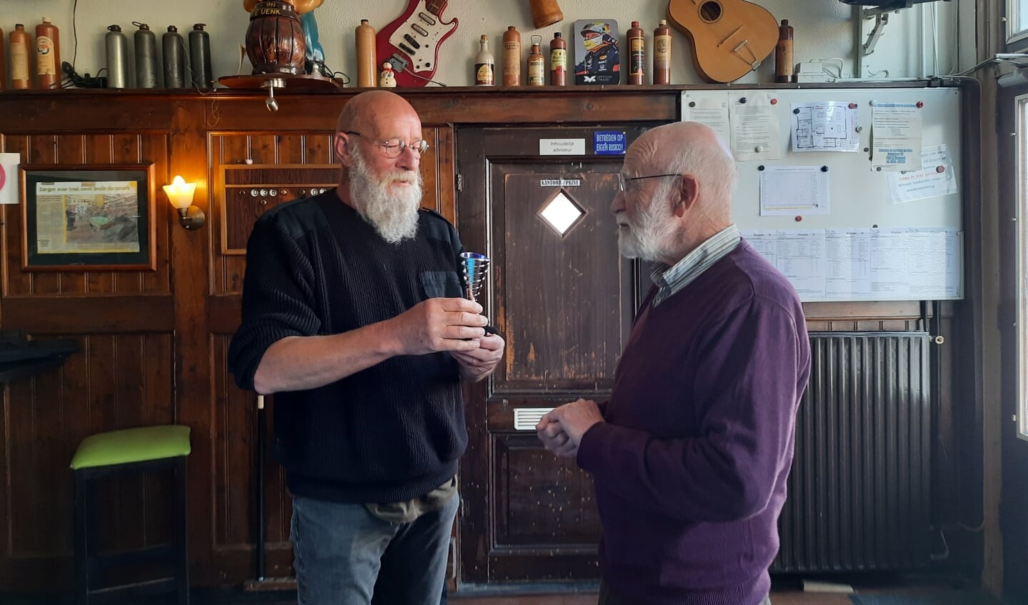 Kampioen Fleming (l) bekijkt de Kampioensbeker, rechts voorzitter Johan Besselink. Foto: Op Goed Geluk