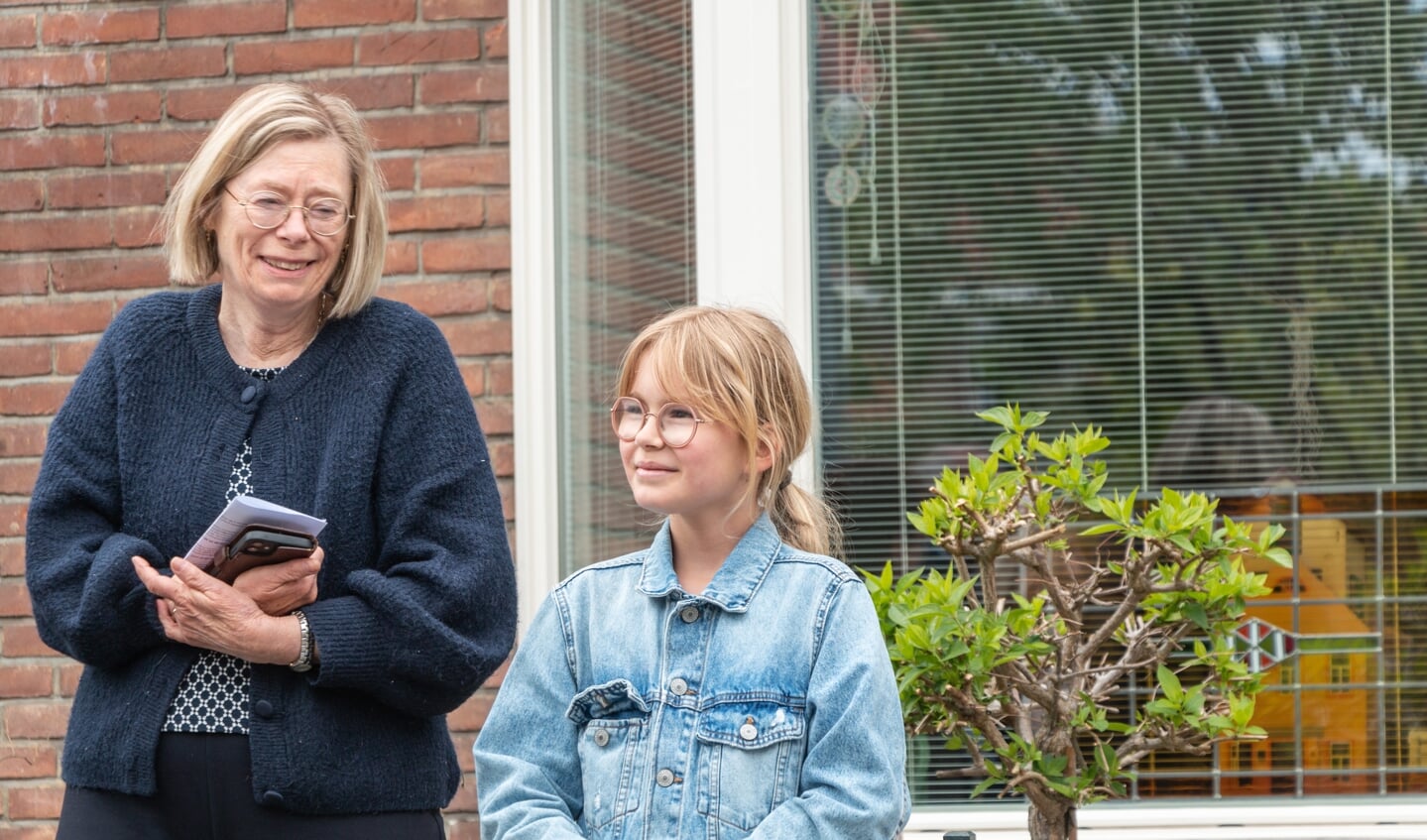 Jip (10) met haar oma na het voorlezen van haar verhaal bij de drie Stolpersteine voor de familie Hanouwer. Foto: Henk Derksen