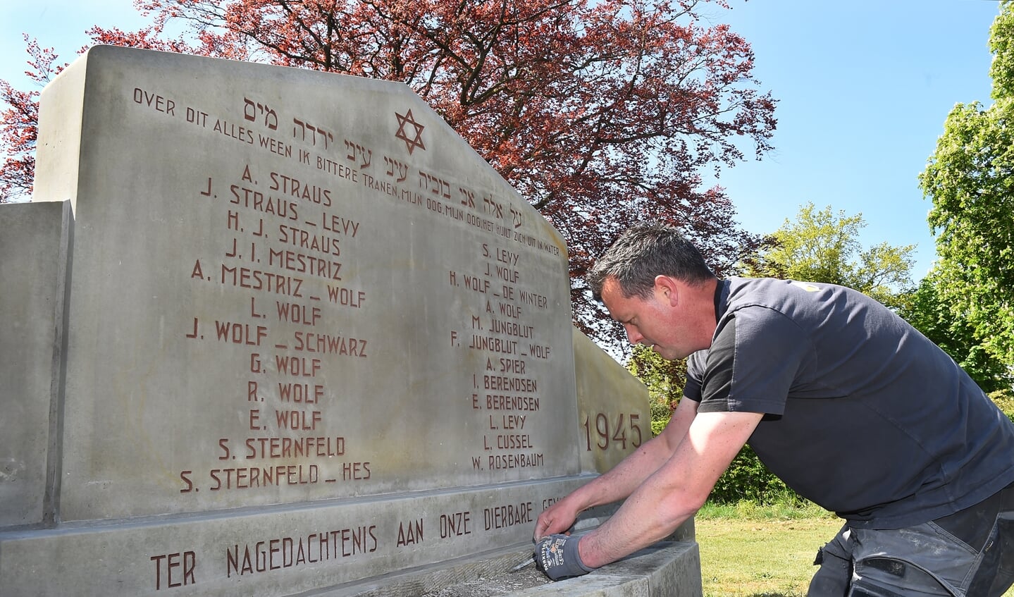 Bas Mulder van de firma Slotboom uit Winterswijk restaureert de gedenksteen voor de joodse Terborgse slachtoffers in de Tweede Wereldoorlog. Foto: Roel Kleinpenning   
