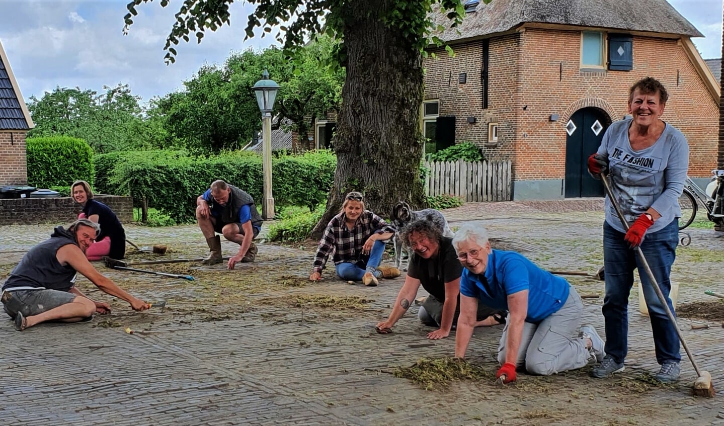 Een aantal van de goedgemutste twintig vrijwilligers die de handen uit de mouwen staken om het plein achter de kapel in hun stadje Bronkhorst te ontdoen van onkruid. Foto: Alice Rouwhorst