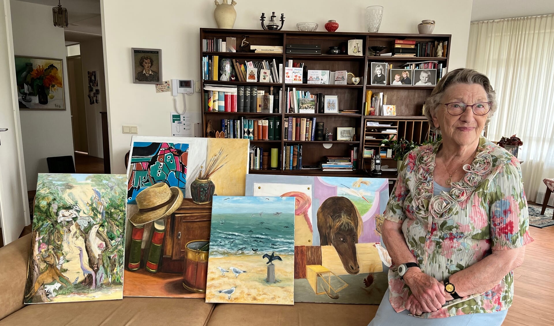 Mevrouw Jos Slootweg met enkele schilderijen die ze maakte. Foto: Karin van der Velden