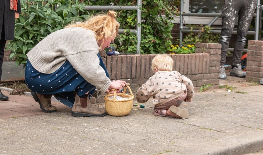 Noud (3) en zijn moeder Loes leggen zelf beschilderde steentjes bij de Stolpersteine voor Bertha van Gelder en haar dochter Elisabeth. Foto: Henk Derksen