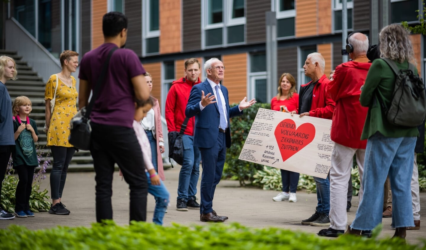 Rolf de Folter (m) neemt het bord aan van de SP, in het bijzijn van verontruste inwoners. Foto: PR
