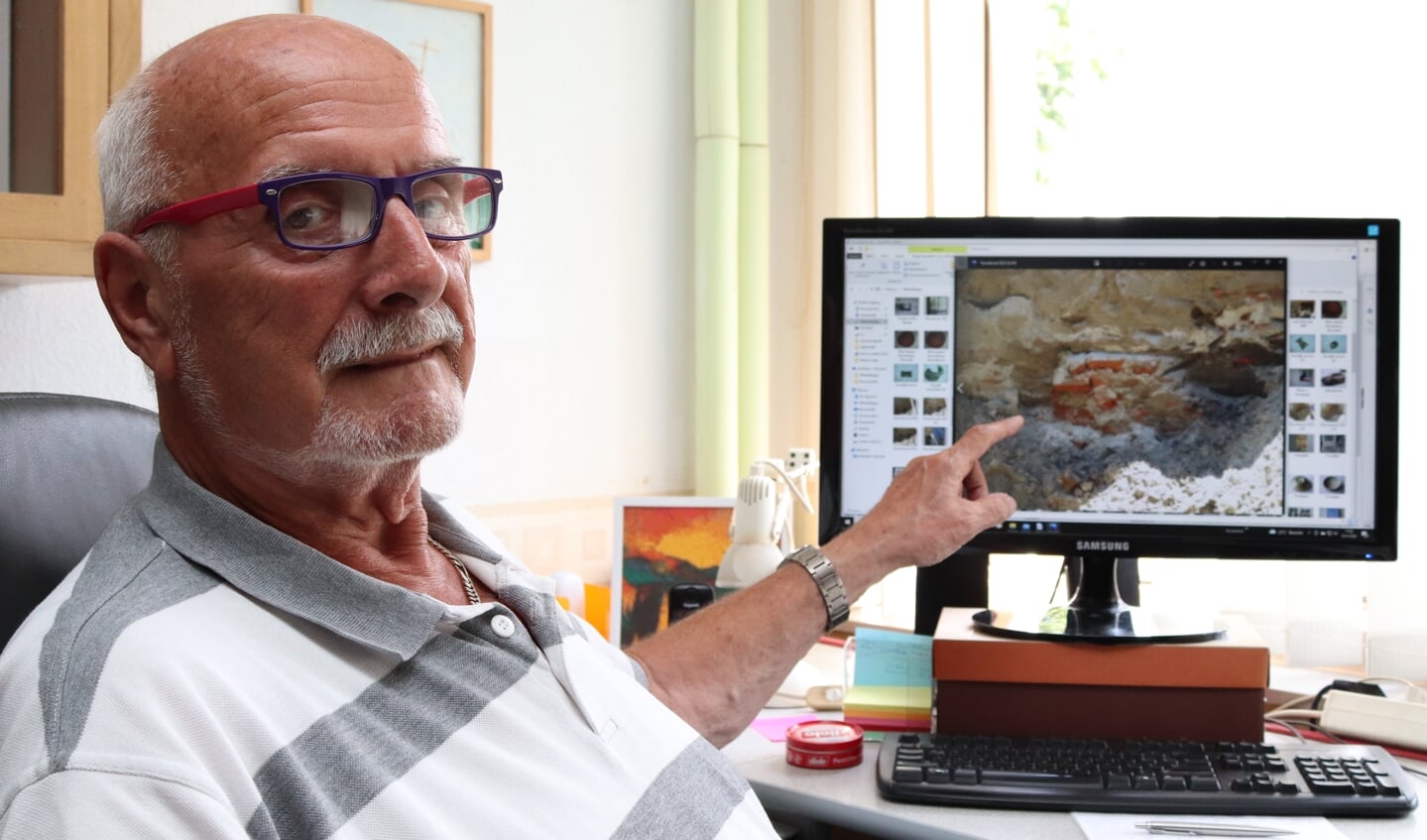 Ben de Graaf wijst naar de foto op het scherm waar een gedeelte van de stadsmuur uit 1250 zichtbaar is. Foto: Arjen Dieperink