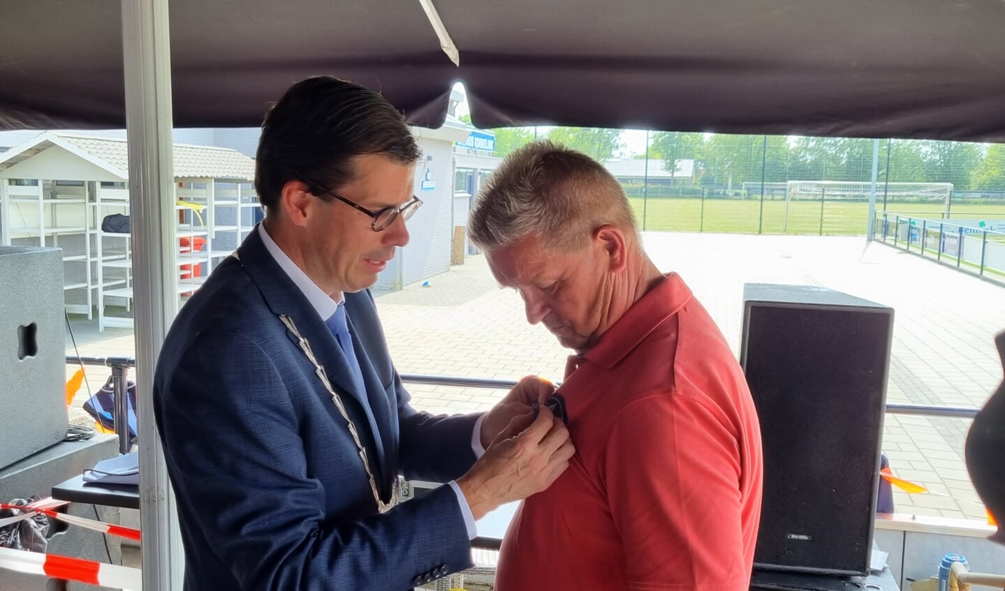 Burgemeester Joost van Oostrum spelt Henk Boevink het lintje Lid in de Orde van Oranje Nassau op. Foto: Rob Weeber