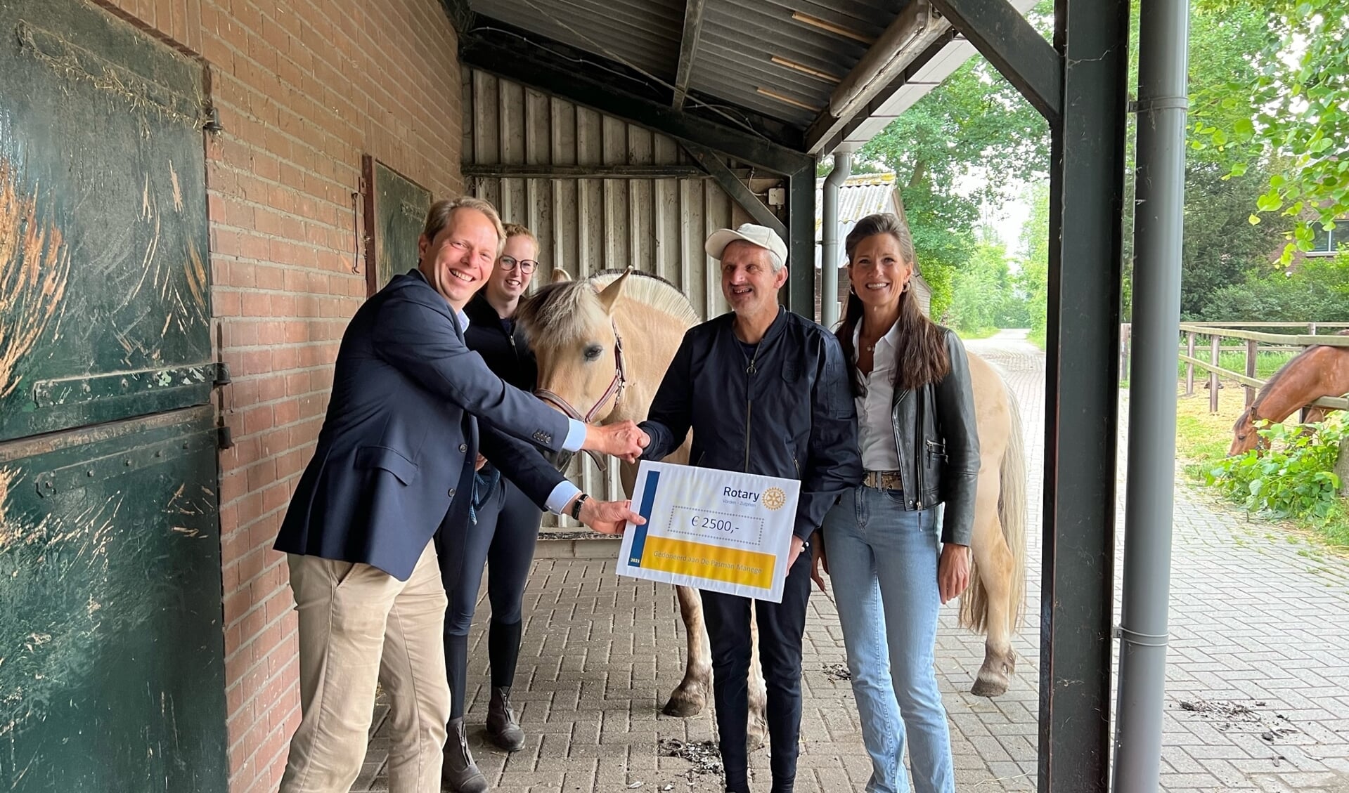 Bernhard Haacker overhandigt namens Rotary Vorden-Zutphen een cheque van 2500 euro aan Ingrid van Dijk en Henk van de Pasmanmanege. Foto: PR