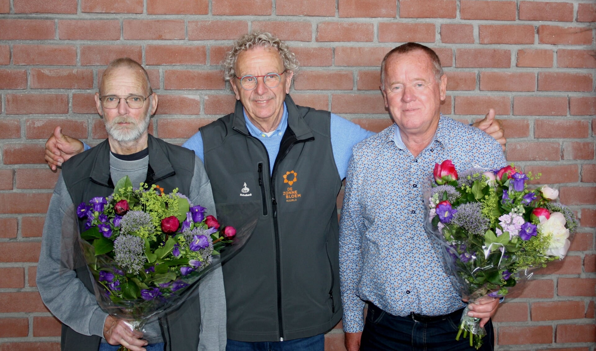 Jan Ligtenbarg (l) en Aloys Hummelink (r) kregen op de jaarlijkse picknick van de voorzitter Koos Luurs (m) een oorkonde en speldje voor hun inzet van de afgelopen tien jaar. 