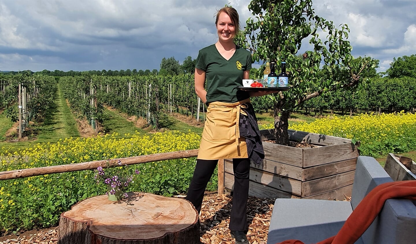 Sophie Horstink op haar terras van ciderproeverij De Groote Wei die uitkijkt over de boomgaard. Foto: Alice Rouwhorst