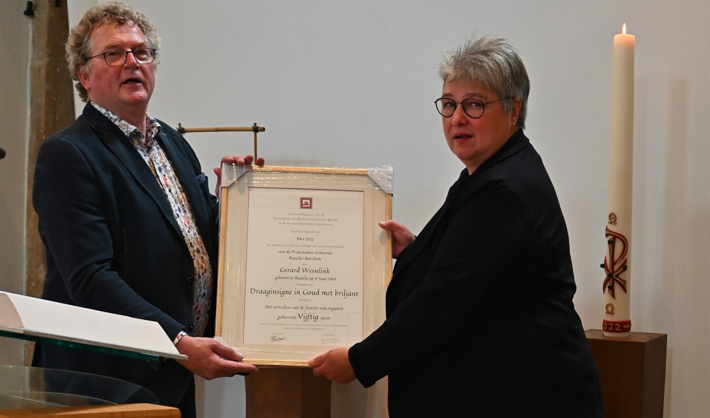 Ouderling kerkrentmeester Gerrie te Winkel overhandigde namens de Vereniging voor Kerkrentmeesterlijk Beheer van de Protestantse Kerk Nederland aan Gerard Wesselink de draaginsigne in goud met briljant en een oorkonde. Foto: Hendrik Jan Oltvoort