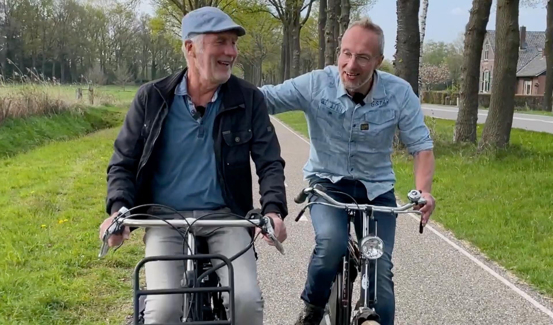 De buurtbewoners Gerrit Rossel (l) en Frank ten Damme maakten al fietsend in de film een rondgang door buurtschap Delden. Foto: PR