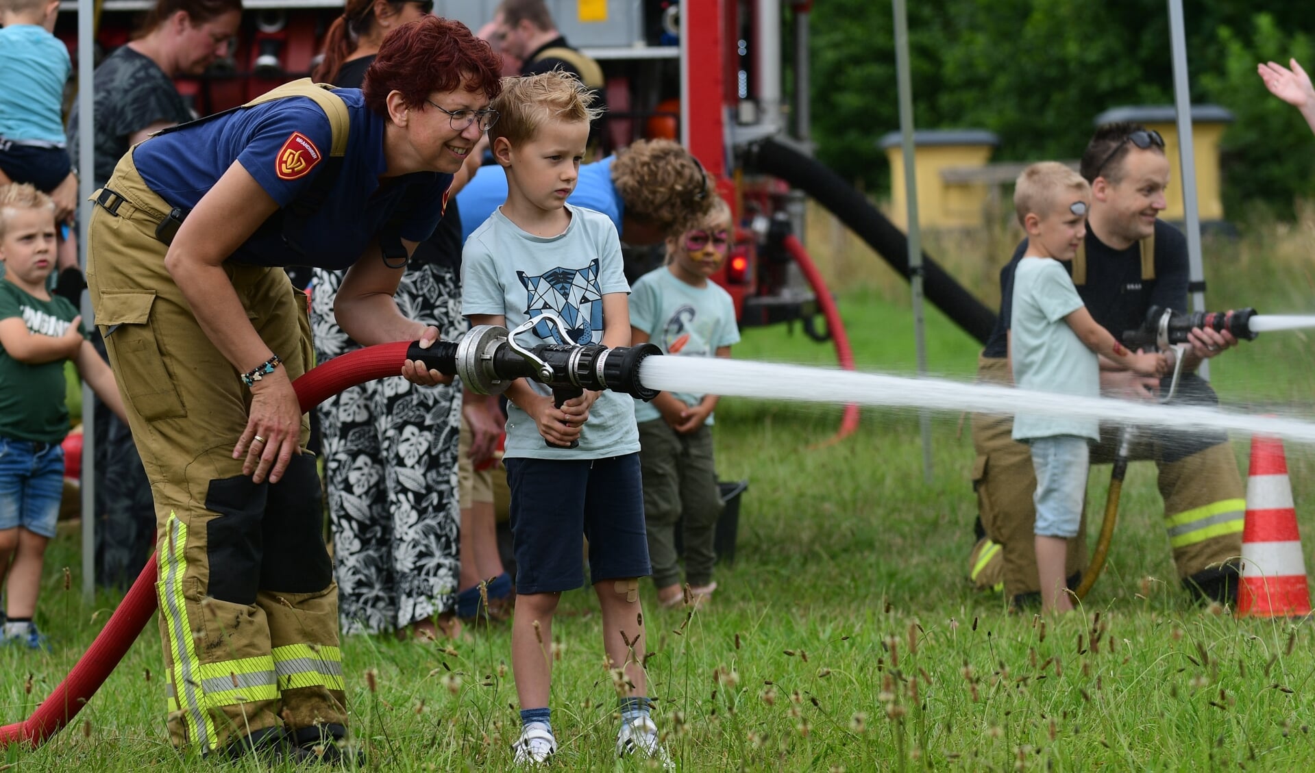 Onder leiding van de brandweer mochten kinderen met een echte brandweerslang spuiten. Foto: AchterhoekFoto.nl/Paul Harmelink