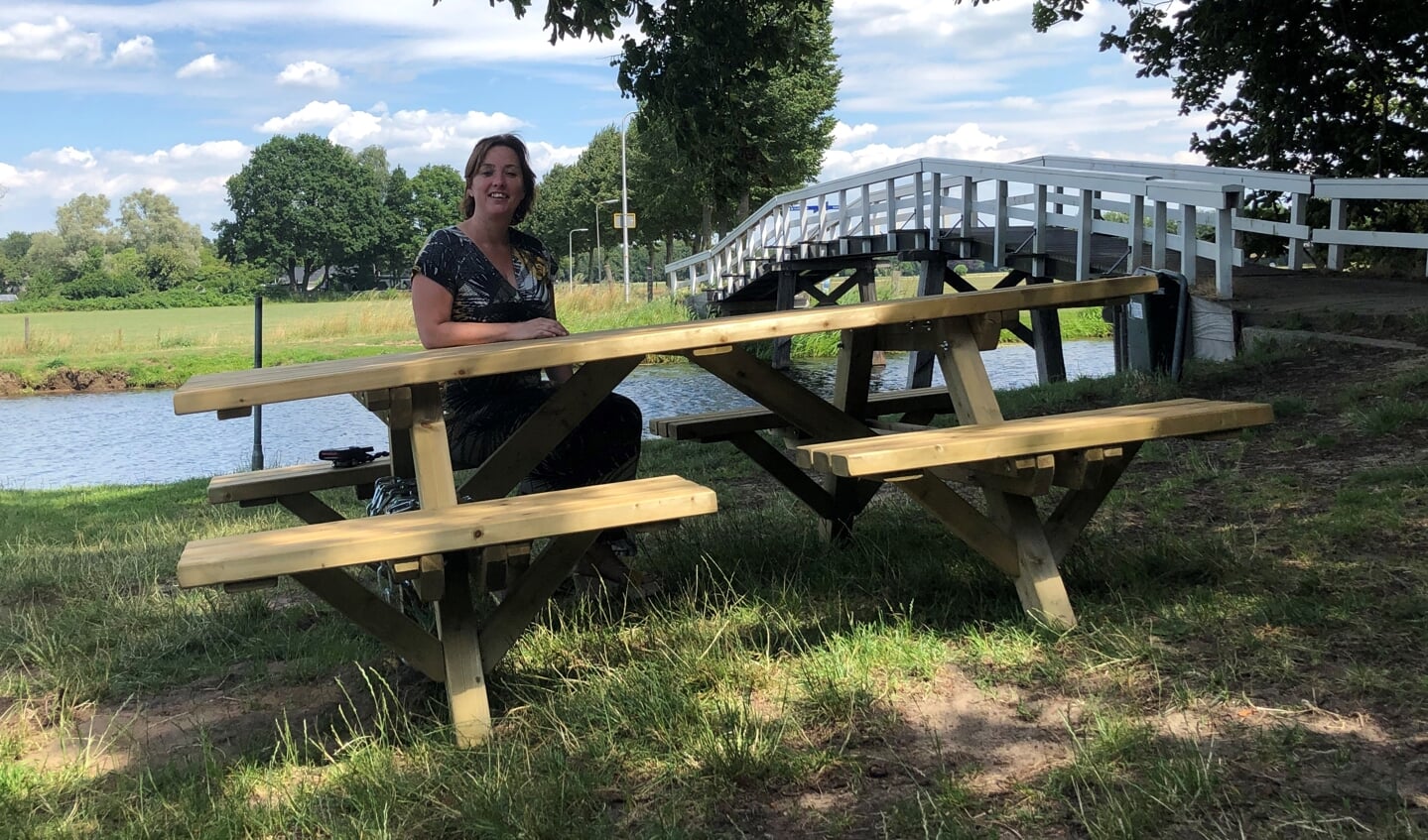 Initiatiefneemster Elsitha Turnhout zittend aan de pas geplaatste picknicktafel bij het witte bruggetje over de Berkel. Foto: Emy Vesseur