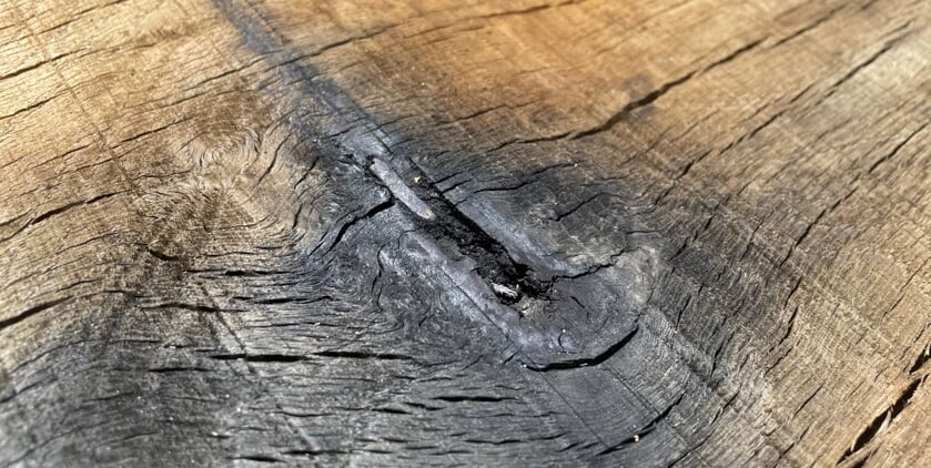 Een van de bomscherven in de bank. Foto: Kees van der Werf