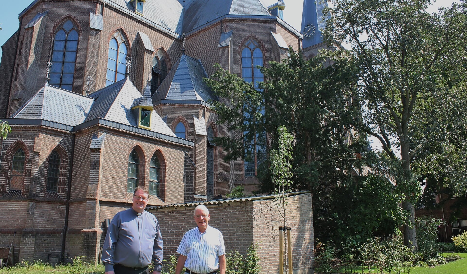 Pastoor Marc Oortman en gebouwbeheerder van de Sint Pancratiuskerk Jan Loskamp in de tuin achter de Pancratiuskerk. Foto: Marlous Velthausz