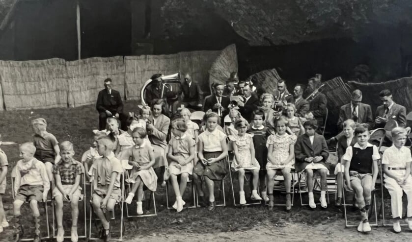 Kinderen kijken naar een voorstelling. Het terrein is met biezen matten afgezet. Foto: PR