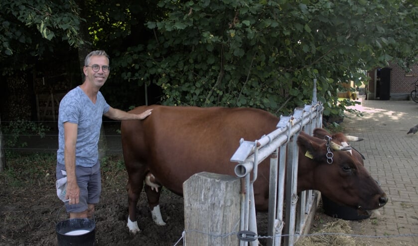 Geert Kobus met een emmer melk bij zijn brandrood rund. Foto: PR