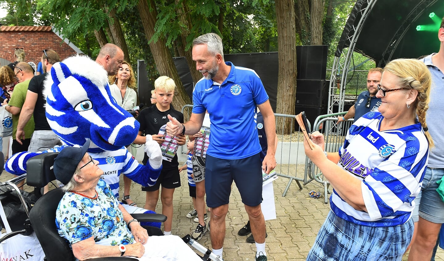 Mascotte Guus, de 93-jarige Hennie Klein in de rolstoel met trainer Adrie Poldervaart; dochter Jacquliene legt het moment vast. Foto: Roel Kleinpenning