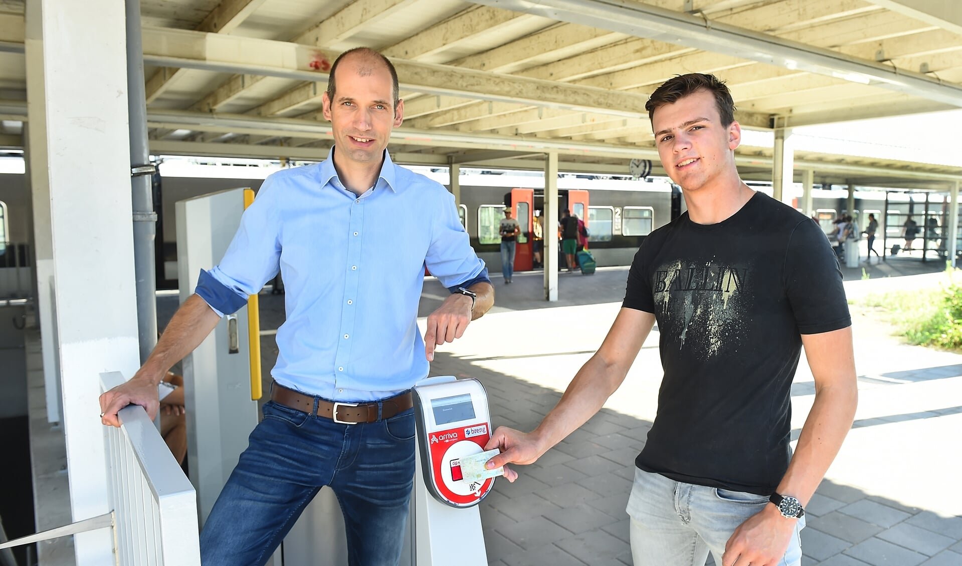 Tim Terhorst (links) en Morris van Dee met de ov-jaarkaart op treinstation Emmerich. Foto: Roel Kleinpenning