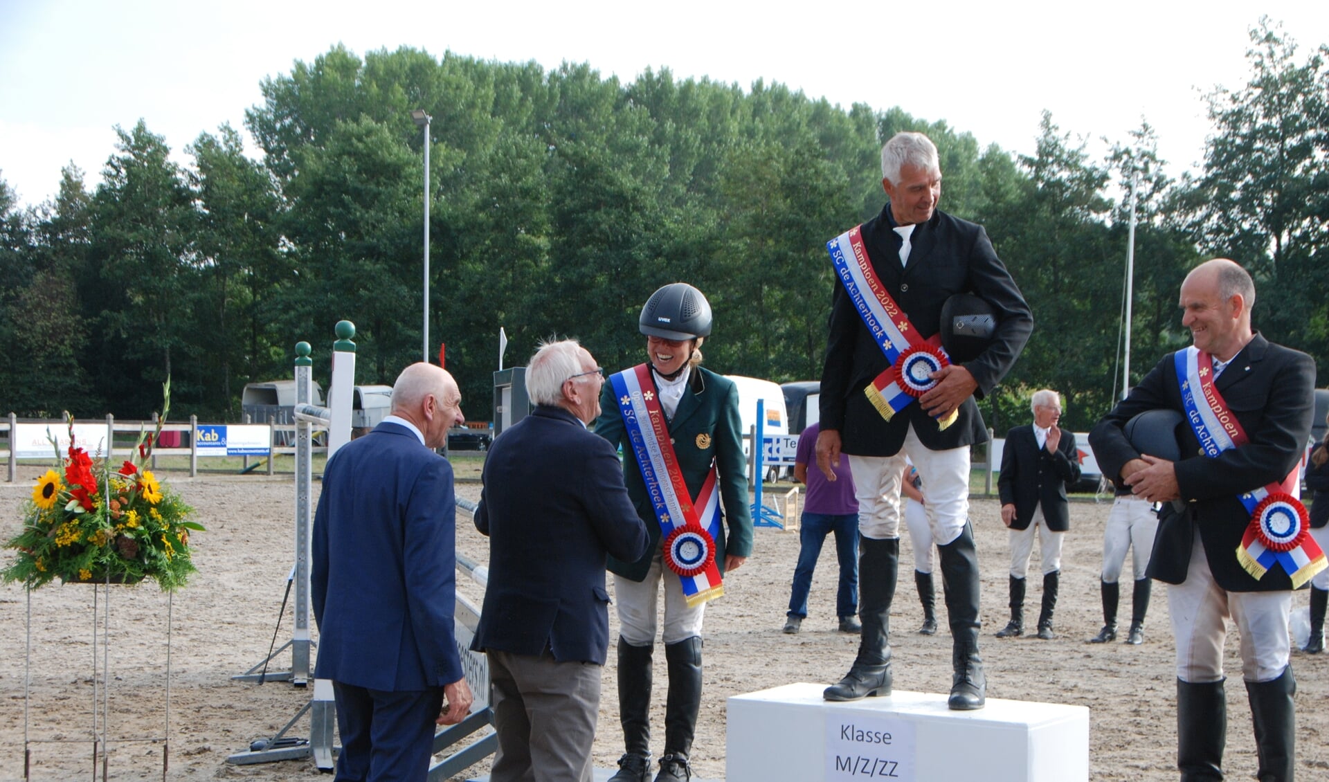 De juryleden Bretveld (links) en Van Zadelhoff feliciteren de kampioenen v.l.n.r. Hylkema, Winkoop en Harmelink. 