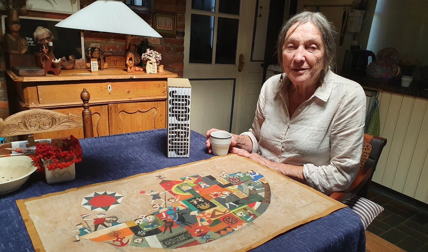 Minnie Kruip aan de keukentafel met de schets van de muurschildering en het fraaie boekwerk 'Joop Kruip.' Foto: Henri Walterbos