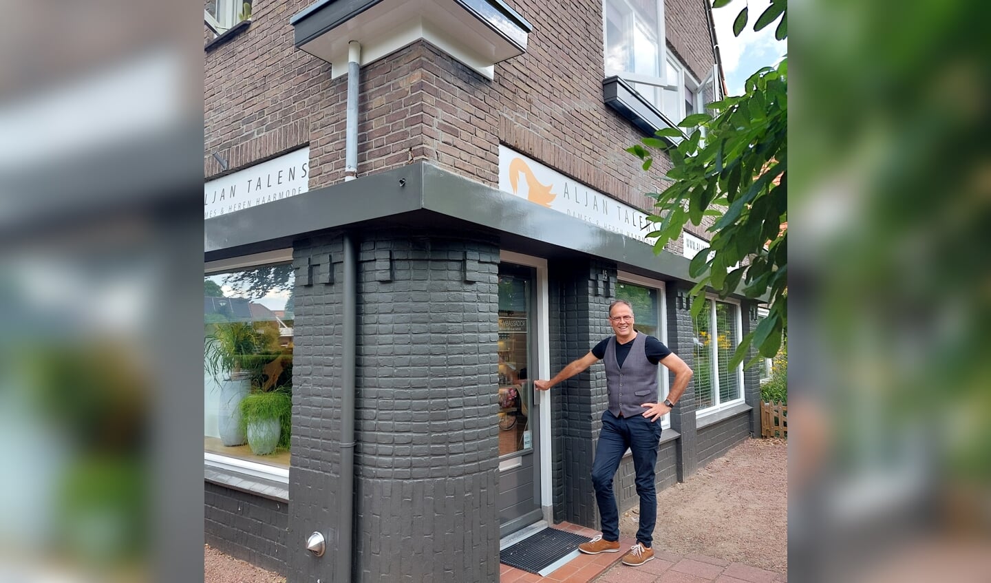 Aljan Talens bij de ingang van zijn kapperszaak, een karakteristiek pand uit 1932. Foto: Meike Wesselink